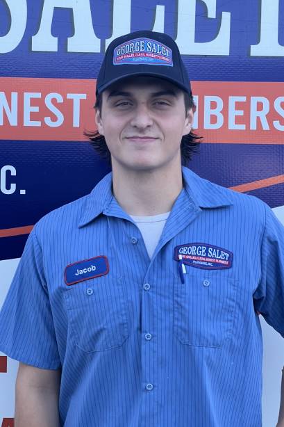 a man in a blue shirt standing in front of a sign