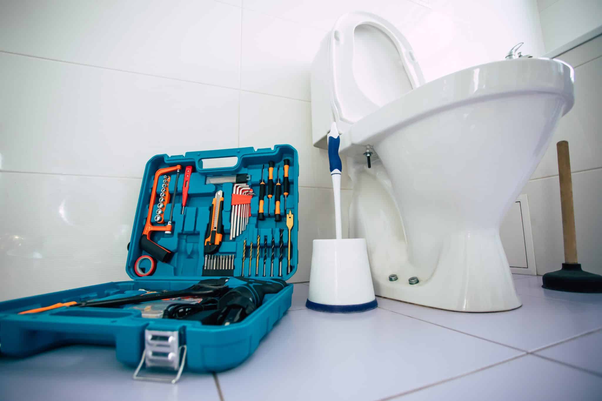 Close-up of a toilet with a toolbox beside it while choosing toilet repair or replacement in a San Francisco home.