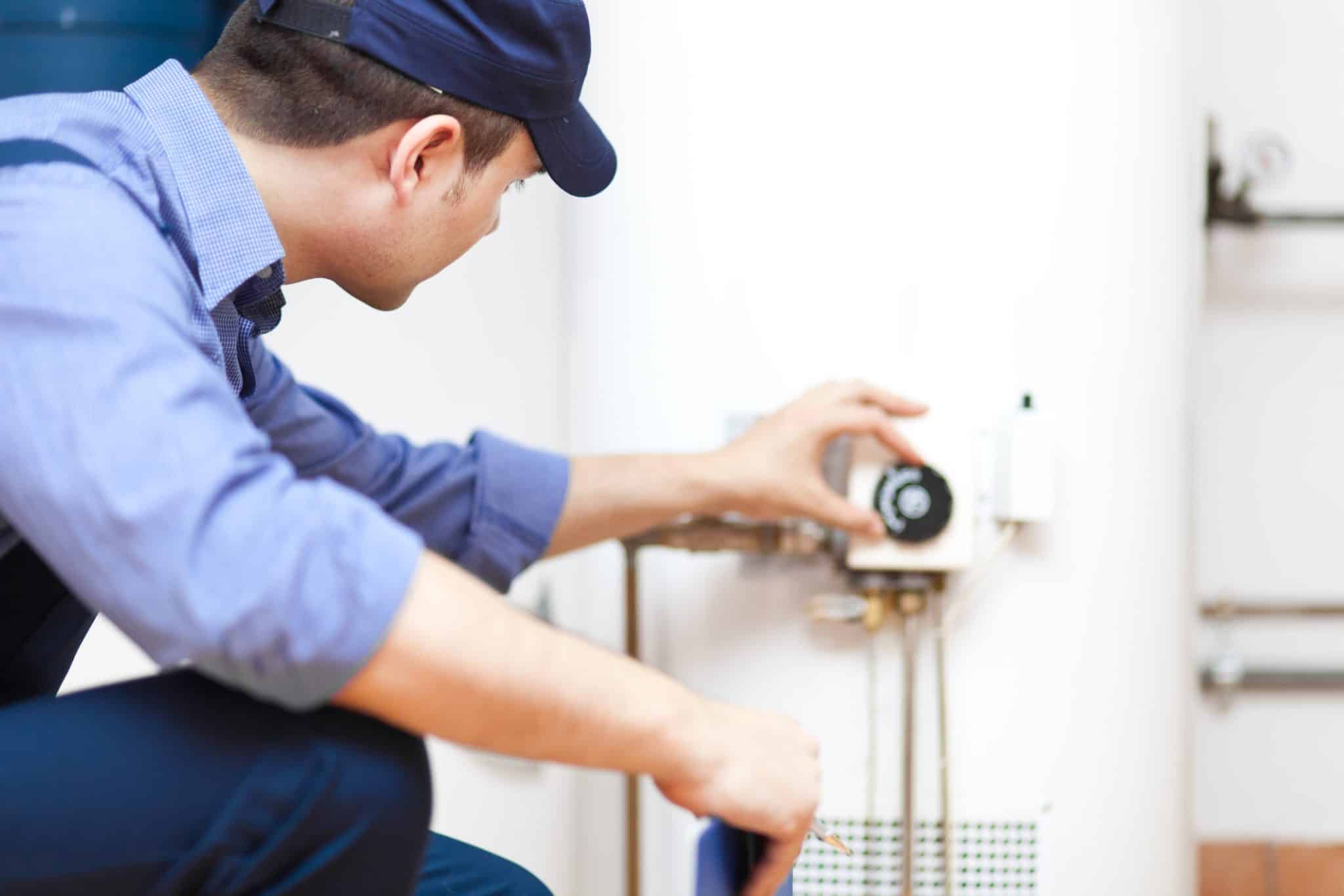 San Francisco plumber checking water heater to see if it is need of flushing to prevent buildup.